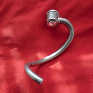 May include: A silver metal bread dough hook for a stand mixer.
