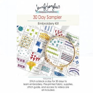 May include: A close-up of a white fabric sampler with colourful embroidery stitches. The fabric is labelled with the names of each stitch, such as "woven cross", "running stitch", and "colonial knot". The sampler is part of a 30-day embroidery kit, volume 2, and includes pre-printed fabric, supplies, a stitch guide, and access to videos.