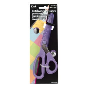 Może przedstawiać: Fioletowe nożyczki do patchworku z osłoną ochronną, prezentowane na czarnym i kolorowym tle. Nożyczki są oznaczone jako "Patchwork Scissors" i mierzą 21 cm długości. Opakowanie zawiera tekst w wielu językach.