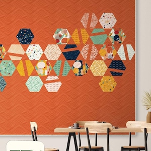 May include: An orange quilt with a geometric pattern of colorful hexagons. The quilt features the text "HEXAGON LOVE" at the top. The bottom left corner has the text "ZEN CHIC" and "BRIGITTE HEITLAND".