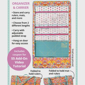 May include: A Ruler Wrap organiser and carrier in pink, orange, and teal. The wrap features pockets and a cutting mat. Text on the wrap reads "Ruler Wrap", "Organizer & Carrier", and "byannie.com". Includes a coupon for a video tutorial.