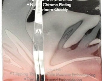Può includere: Forbici da ricamo argentate con un designo a lama curva. Le forbici sono confezionate in un sacchetto di plastica trasparente con sfondo rosso e bianco. La confezione include il testo "JANOME MACHINE EMBROIDERY SCISSORS" e "PART #EMBSCISSOR".