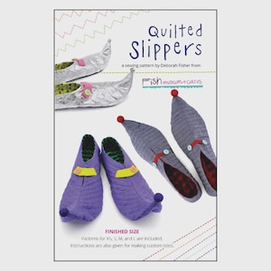 May include: A sewing pattern for quilted slippers. The image shows several pairs of slippers in various colors and designs, including purple, silver, and gray. The slippers have decorative elements like buttons and pom-poms. Text on the image reads "Quilted Slippers" and "Fish museum+circus."