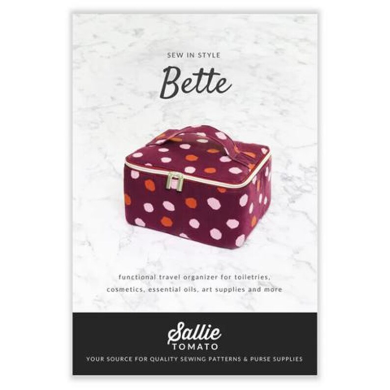 K&ouml;nnte beinhalten: Ein burgunderfarbener Reiseorganizer mit einem pinkfarbenen und orangenfarbener Tupfenmuster. Der Organizer hat einen Rei&szlig;verschluss und einen oberen Griff. Der Text "SEW IN STYLE Bette" befindet sich oben im Bild. Der Text "Sallie TOMATO YOUR SOURCE FOR QUALITY SEWING PATTERNS & PURSE SUPPLIES" befindet sich unten im Bild.