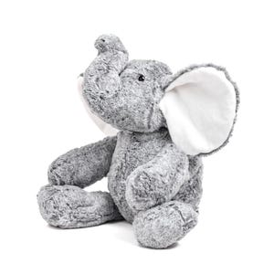 Peut inclure: Une peluche éléphant grise avec de grandes oreilles doublées de blanc et une trompe levée. Le jouet en peluche est assis, les bras et les jambes tendus. L'éléphant a un aspect doux et texturé sur un fond blanc.