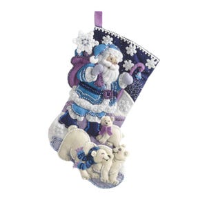 Può includere: Una calza di Natale decorativa con un Babbo Natale in abito blu, barba bianca e sacco viola. La calza è decorata con fiocchi di neve e orsi polari. Ha un anello viola per appenderla.