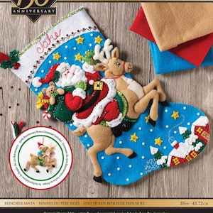 Könnte beinhalten: Ein blauer Weihnachtsstrumpf aus Filz mit einem Design von Weihnachtsmann und Rentier. Der Strumpf ist mit Sternen, einem Haus und Schneeflocken verziert. Er ist 45,72 cm lang und enthält einen Bonus-Ornament.