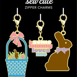 Puede incluir: Tres abalorios de cremallera dorados con un conejito, una cesta de huevos de Pascua y el texto "some bunny loves me". Los abalorios están sobre un fondo negro con el texto "Cathe Holden's sew cute zipper charms" y "moda fabrics + supplies".