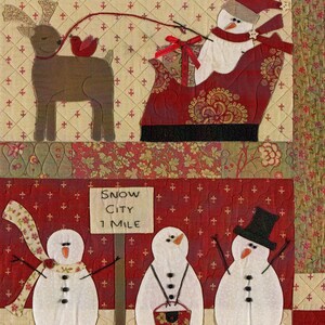 Puede incluir: Un tapiz de pared acolchado con un mu&ntilde;eco de nieve montando en un trineo tirado por un reno. El letrero dice "Snow City 1 Mile".