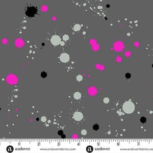 May include: A gray fabric with a repeating pattern of pink, black, and gray paint splatters. The fabric is measured with a ruler in inches.