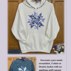 May include: White hooded sweatshirt and denim jacket featuring a Double Aster applique quilt design. The applique design is a starburst pattern in shades of blue and purple. The image also includes text that reads "Charming Applique Double Aster Block."