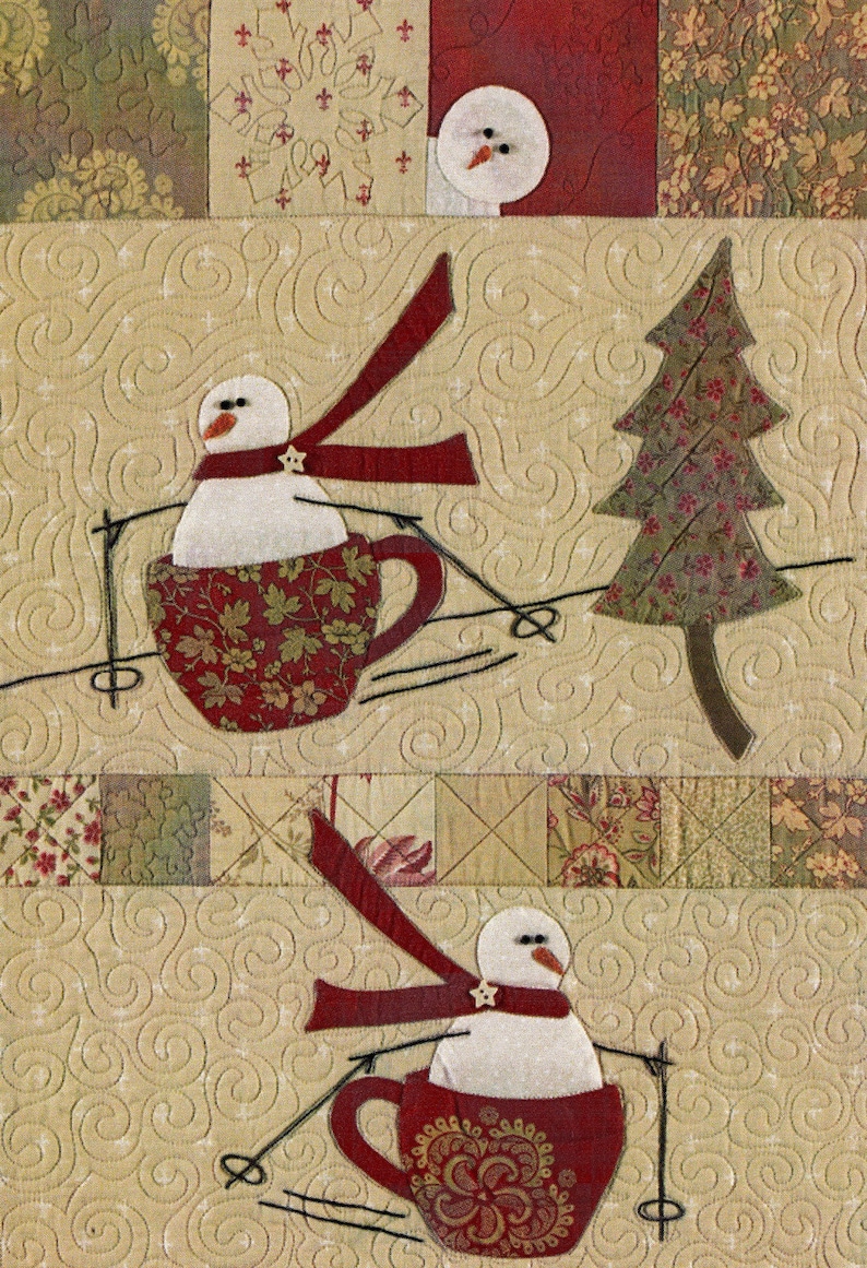 Puede incluir: Dos mu&ntilde;ecos de nieve en tazas rojas con bufandas rojas est&aacute;n esquiando cuesta abajo. El fondo es una tela beige con un patr&oacute;n acolchado.
