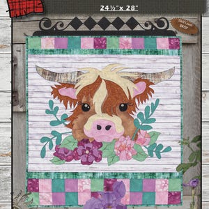 Könnte beinhalten: Ein Highland Cow Quiltmuster mit dem Text "HIGHLAND COW" und den Maßen 62,2 cm x 71,1 cm. Der Quilt zeigt ein Kuhgesicht mit braunem und weißem Fell, großen Hörnern und floralen Akzenten. Der Schwierigkeitsgrad ist mit "EINFACH" gekennzeichnet.