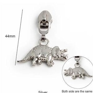 May include: Silver zipper pull with a 3D triceratops design. The pull measures 44 mm in length. Both sides of the pull are the same.