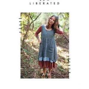 Pode incluir: Uma mulher vestindo um vestido azul e vermelho em camadas com um bolso na frente. O vestido se chama "Metamorphic Dress" e é da marca "Sew Liberated".
