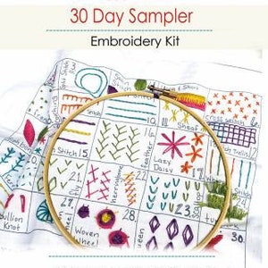 May include: A white fabric sampler with a hoop and colorful embroidery stitches. The fabric is pre-printed with a grid and numbers. The text on the fabric reads "30 Day Sampler Embroidery Kit".