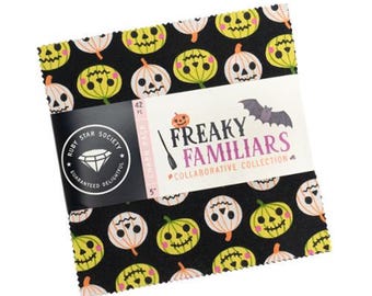 May include: A Halloween-themed fabric charm pack with a black background and a repeating pattern of pumpkin faces in white and yellow. The pack is labelled "Freaky Familiars" and includes a Ruby Star Society logo.