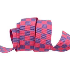May include: Pink and purple checkered ribbon. The ribbon is woven with a checkered pattern and is perfect for crafting and decorating.