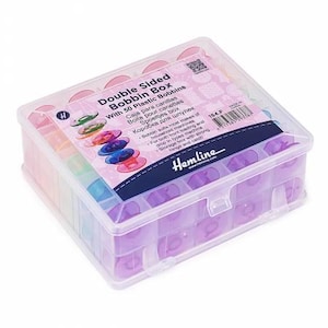 May include: A clear plastic double-sided bobbin box containing 50 plastic bobbins. The box has a hinged lid and is labeled "Double Sided Bobbin Box With 50 Plastic Bobbins." The bobbins are various colors, including purple, green, and blue.