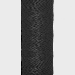 May include: A spool of black Gütermann sewing thread. The spool is cylindrical with a white base and a cream-colored top with the Gütermann logo. The label indicates 100 meters or 110 yards of thread.