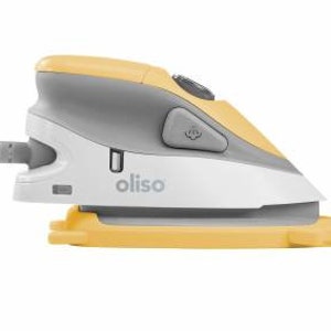 Puede incluir: Una plancha peque&ntilde;a, de mano, amarilla y gris con una base blanca. La plancha tiene un cable de alimentaci&oacute;n y un bot&oacute;n en el lateral. La plancha est&aacute; etiquetada con "oliso".