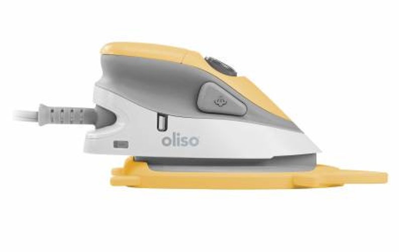 Puede incluir: Una plancha peque&ntilde;a, de mano, amarilla y gris con una base blanca. La plancha tiene un cable de alimentaci&oacute;n y un bot&oacute;n en el lateral. La plancha est&aacute; etiquetada con "oliso".