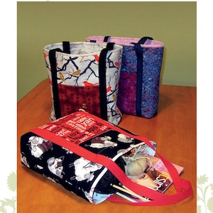 May include: Three fabric tote bags with black handles. One bag has a black and white sheep pattern, another has a bird and branch pattern, and the third has a purple and blue floral pattern. The bags are labeled "Sassy Soho Shopper."