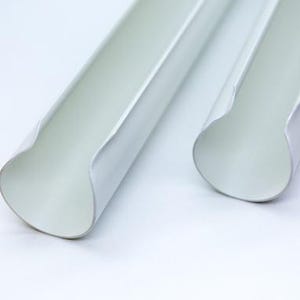 Puede incluir: Dos tubos de plástico blanco con extremos redondeados. Los tubos son huecos y tienen un acabado liso y brillante.