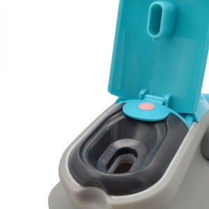 Puede incluir: Una botella de agua gris y azul con una tapa abatible. La tapa est&aacute; abierta y la botella tiene un sello de goma negro alrededor de la abertura.