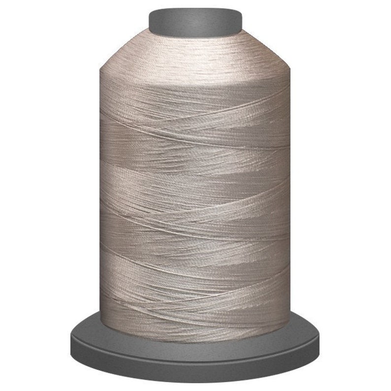 May include: A spool of light beige thread for sewing or embroidery.