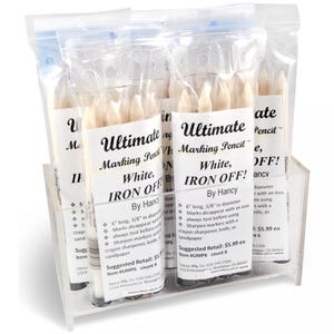 May include: A display of six packs of white marking pencils, each pack labelled "Ultimate Marking Pencil" with the text "White, Iron Off!" and "By Hancy". The pencils are 15.2 cm long and 1 cm in diameter. The suggested retail price is £5.99 each.