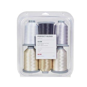 May include: A set of five spools of Glide trilobal polyester top thread in a clear plastic package. The spools are arranged in two rows, featuring white, light gray, dark gray, and cream colors. The label reads PERFECT BLEND GLIDE.