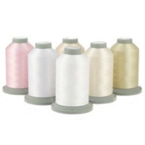 May include: Five spools of thread in various shades of white, cream, and pink. The spools are arranged in a row on a white background.