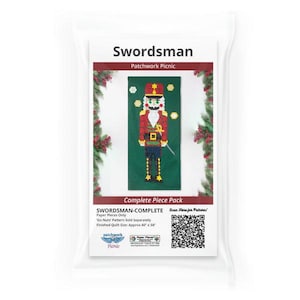 Puede incluir: Un paquete para un proyecto de patchwork con un diseño de cascanueces. El paquete está etiquetado como "Swordsman" e incluye el texto "Complete Piece Pack". El tamaño final del edredón es de aproximadamente 101,6 x 147,3 cm.