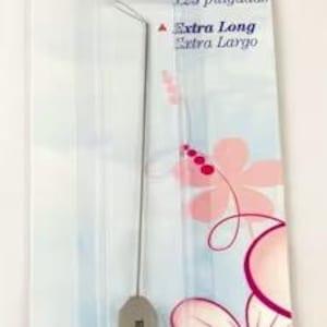 May include: A serger needle threader, 5.25 inches long, packaged on a white and blue card with pink floral accents. The card features the text "SERGER NEEDLE THREADER" and "Extra Long". The threader is gray and silver.