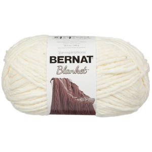May include: A large, off-white ball of Bernat Blanket yarn. The label displays the brand name and a picture of a knitted blanket. The yarn is 10.5 oz / 300 g and made of polyester.