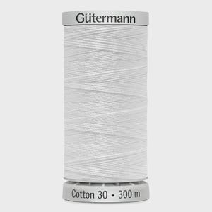May include: A white spool of Gütermann cotton thread. The spool is labeled "Gütermann" at the top and "Cotton 30 • 300 m" at the bottom. The thread is tightly wound, showing a textured surface.