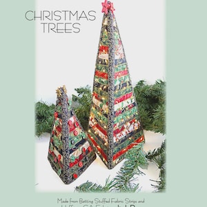 Peut inclure: Deux sapins de Noël en tissu, un grand et un petit, avec des étoiles rouges en guise de décorations. Les arbres sont faits de bandes de tissu et décorés de motifs festifs. Le grand arbre mesure 40.6 cm x 17.8 cm, et le petit arbre mesure 21.6 cm x 12.7 cm.