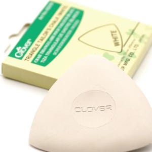 Puede incluir: Tiza de sastre triangular blanca con el nombre de la marca Clover en relieve en la parte delantera. La tiza está empaquetada en una caja con texto verde y blanco que dice "Clover Triangle Tailor's Chalk White".