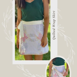 Könnte beinhalten: Weißer, gesteppter Wickelrock mit Patchwork-Design mit rosa und gelben Akzenten. Der Rock hat einen weißen Bindverschluss und ist mit einem goldenen Rand versehen. Der Text "Quilted Wrap Skirt" wird auf dem Bild angezeigt.