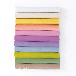 May include: A stack of 12 rolls of felt in various pastel colors, including white, beige, yellow, peach, pink, lavender, purple, blue, green, and brown.