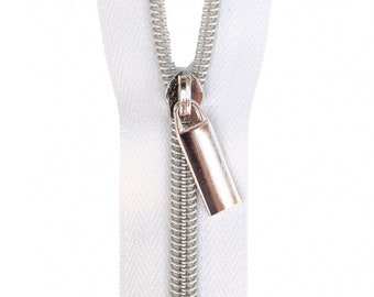 May include: Close-up of a white zip fastener with a silver metal pull tab. The zip teeth are silver and the fabric is white. The pull tab is a small, rectangular shape.