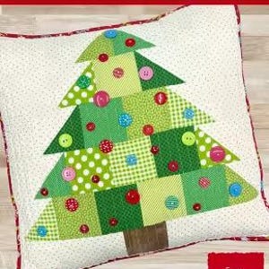 May include: A decorative pillow with a Christmas tree design. The tree is made of green fabric squares and triangles, adorned with colorful buttons. The finished pillow size is 18 inches by 18 inches.
