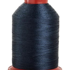 May include: A spool of dark blue thread on a red plastic bobbin.