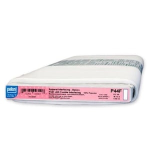 May include: A roll of white P44F JAS fusible interfacing fabric. The pink label displays product information, including the brand name, fabric type, and care instructions. The roll measures 48 inches in width.