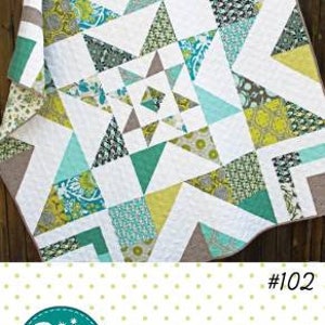 May include: A quilt pattern called "Triple Barnstar" by Amy Gibson. The pattern is available in two sizes and is fat quarter and layer cake friendly. The quilt pattern is shown in a quilt with a white background and green, blue, and brown fabrics.