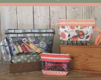 May include: Three zippered pouches labeled The Maddilyn Pouch. The largest has a blue plaid top, floral center, and green polka dot base. The medium has a peach floral print and striped base. The smallest has a red patterned top and base.