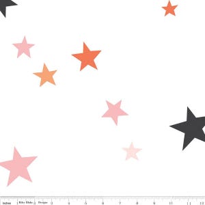 May include: White fabric featuring a pattern of stars in various colours, including pink, orange, and black. The image includes a ruler with inches.