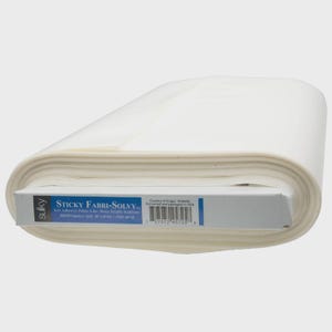 May include: A roll of white Sulky Sticky Fabri-Solvy self-adhesive, fabric-like, water-soluble stabilizer. The product label displays the brand name, product type, and a barcode. The roll measures 20 inches by 25 yards, as printed on the label.