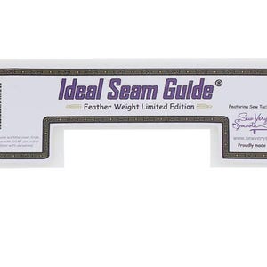 Puede incluir: Una guía de costura de plástico blanco con una etiqueta dorada y morada que dice "Ideal Seam Guide® Feather Weight Limited Edition". La etiqueta también incluye el texto "Featuring Sew Tacky-Technology™ Sew Very Smooth™ www.sewverysmooth.com Proudly made in the USA".